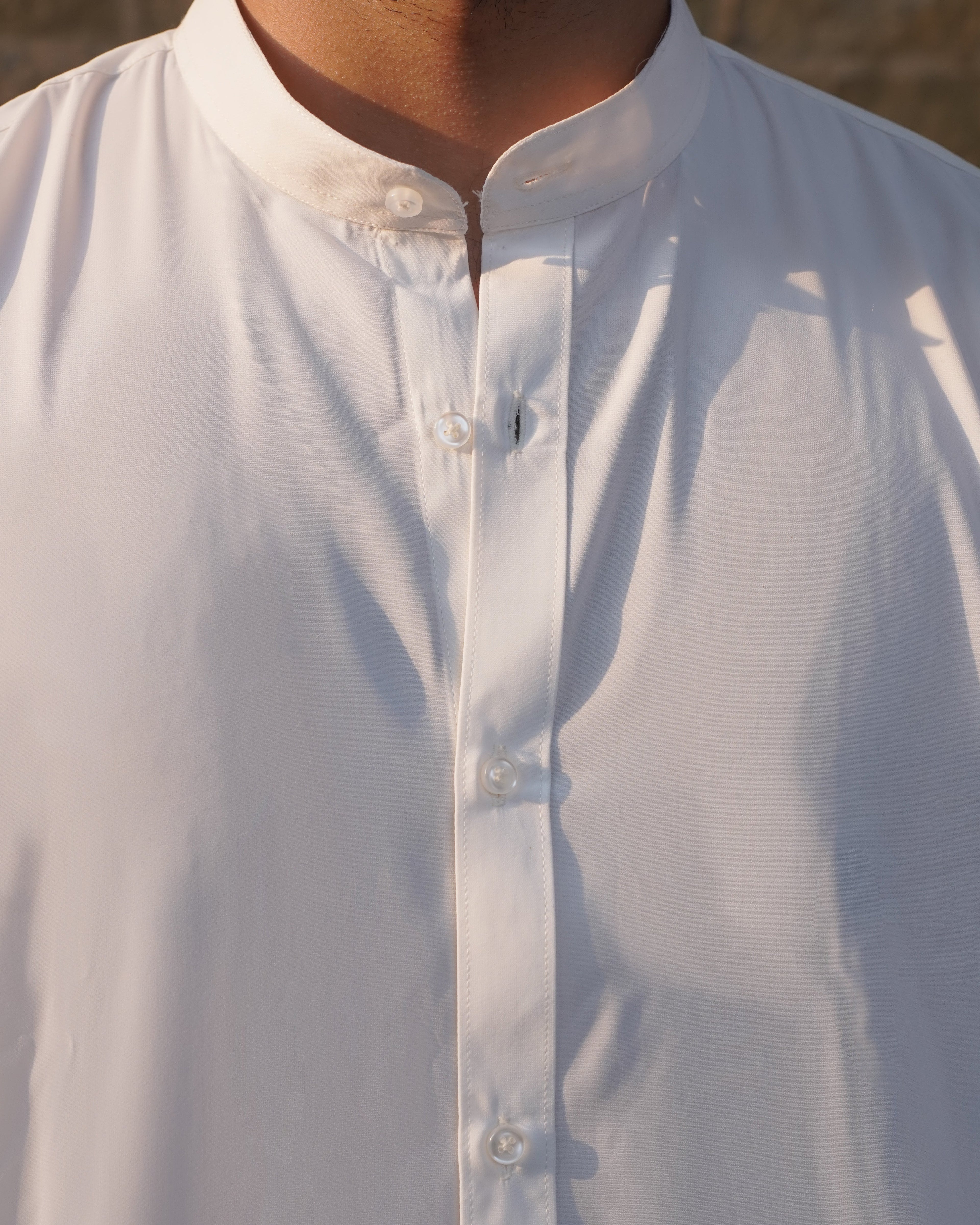 Close-up of a white  button-up shirt with a blurred background