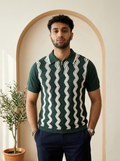 Man wearing a green and white patterned polo shirt standing in front of an archway.